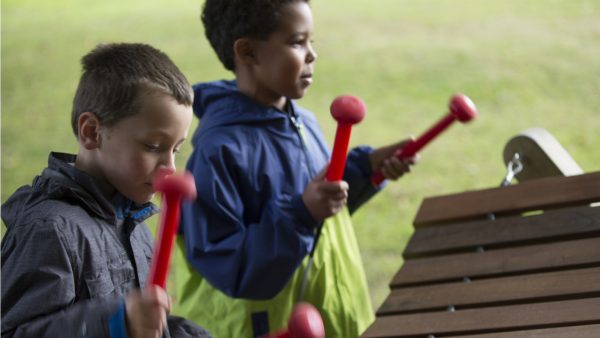 Akadinda Outdoor Music Instrument (2 boys playing; side view)