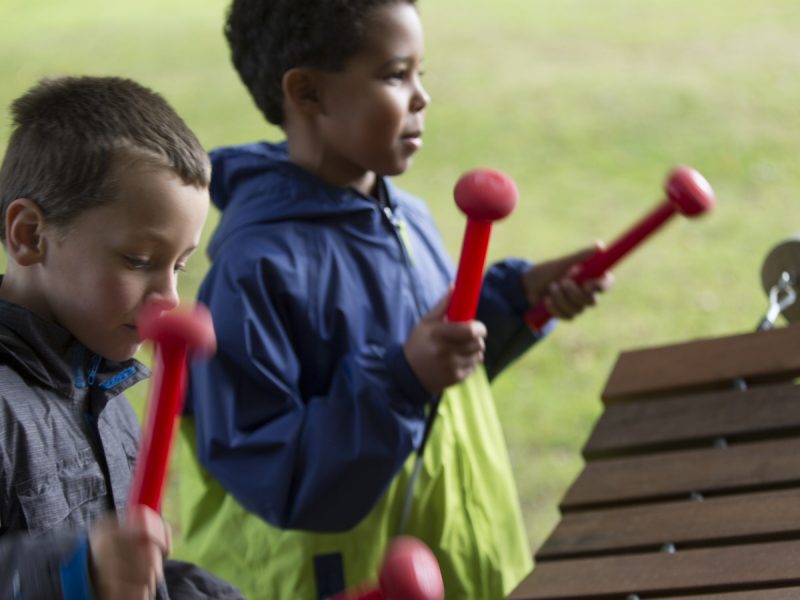 Akadinda Outdoor Music Instrument (2 boys playing; side view)