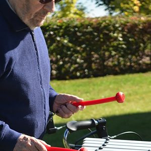 Cadenza Outdoor Music Instrument (older man playing; right side view)