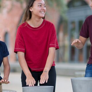 Percussion Play Djembes Ourdoor Drums (1 girl, 2 boys playing)
