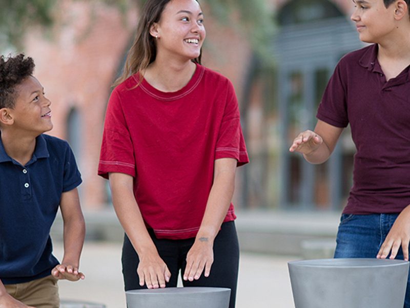 Percussion Play Djembes Ourdoor Drums (1 girl, 2 boys playing)