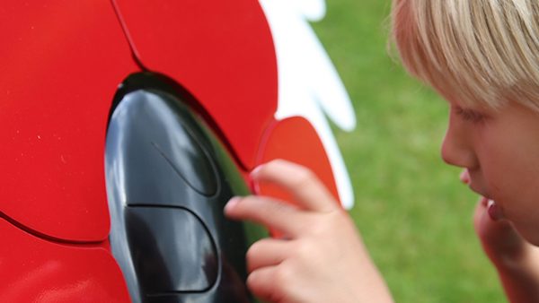 Percussion Play Poppy Petal Drum (young boy playing; close up)