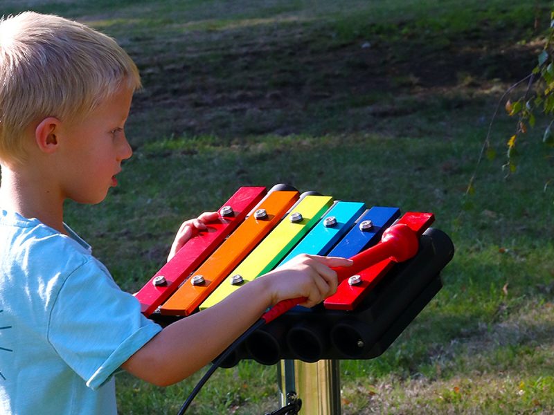 Rainbow Metallophone Outdoor Music Instrument (1 boy playing; right side view)